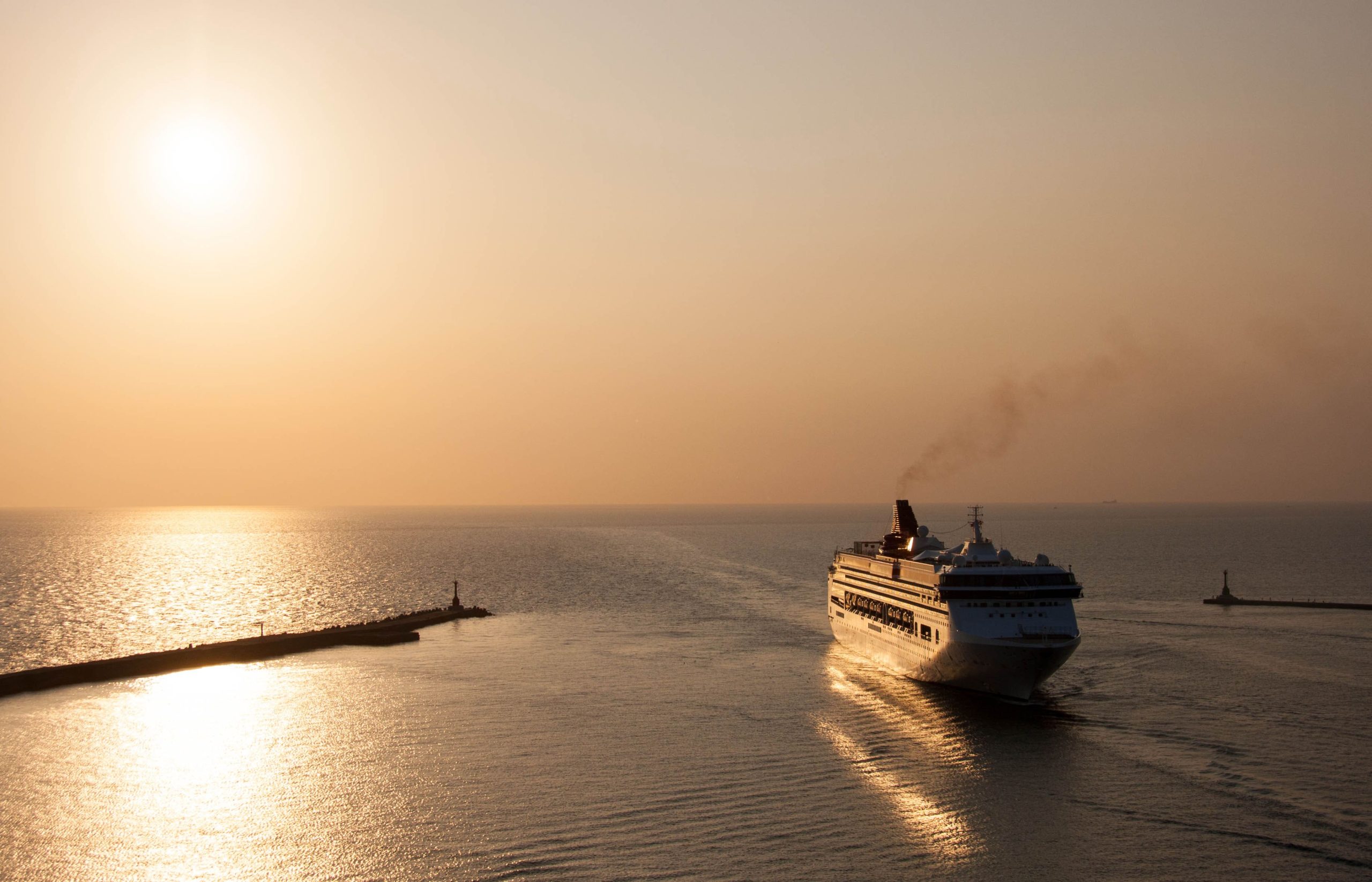 Kreuzfahrtschiff fährt in den Hafen von Kaohsiung ein bei Sonnenuntergang